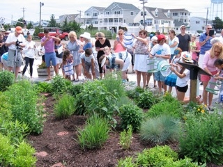 People of different ages stand together in a garden